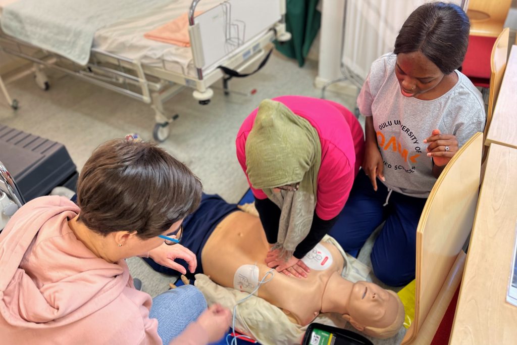 Photo of nursing students practicing how to perform basic cardiopulmonary resuscitation with an automated external defibrillator.