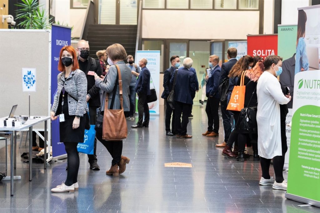 Valokuva eHealth-konferenssin osallistujista ständeillä.