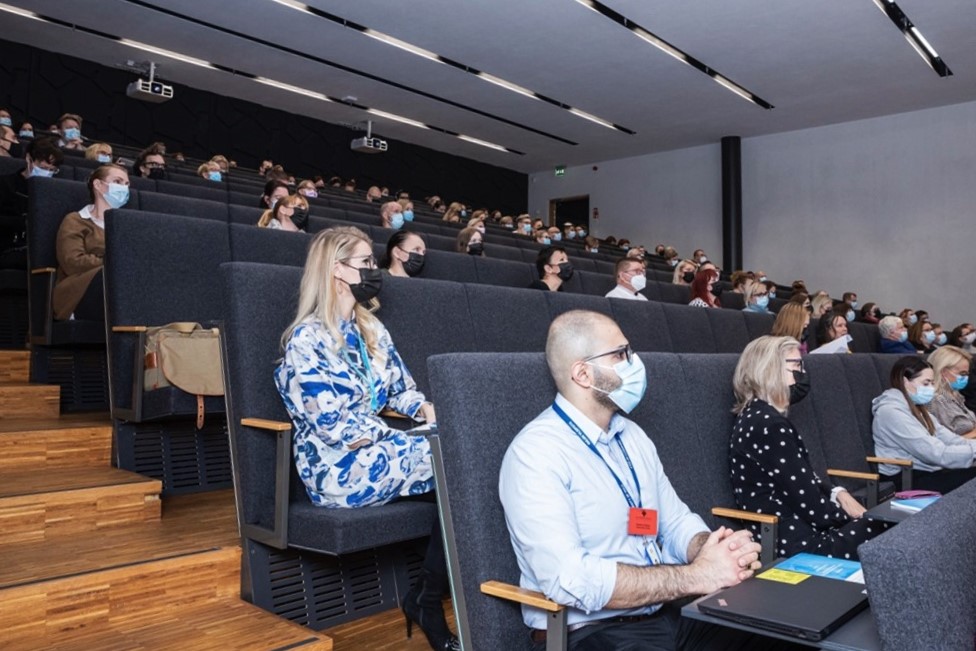 Valokuva eHealth-konferenssin osallistujista istumassa luentosalissa.