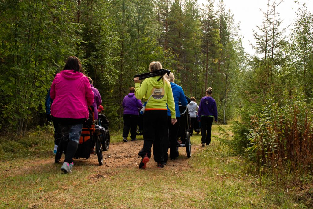 Valokuvassa ihmisiä kävelee metsätietä.