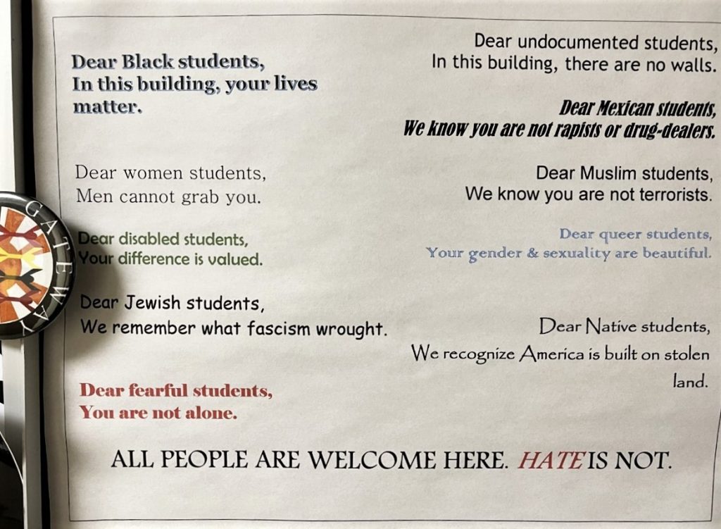 Valokuva, jossa paperilla tekstit: Dear Black Students, In this building, your lives matter. Dear woman students, men cannot grab you. Dear disabled students, your difference is valued, Dear Jewish students, we remember what fascism wrought. Dear fearful studetns, you are not alone. Dear undocumented students, in this building, there are no walls. Dear Mexican Students, we know you are not rapists or drug-dealers. Dear Muslim Students, We know you are not terrorists. Dear queer students, we know your gender and sexuality are beautiful. Dear Native Students, we recognize America is built on stolen land. All people are welcome here. Hate is not.