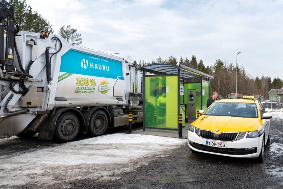 Valokuvassa taksi ja jäteauto tankkaamassa biokaasua.