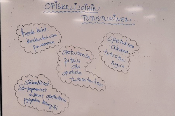 Valokuva luokkahuoneesta, jonka taululla teksti: opiskelijoihin tutustuminen.