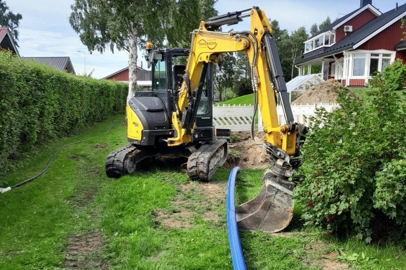 a photo of an excavator digging water pipes into the ground..